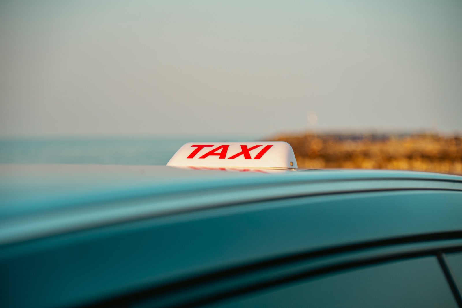 Taxi roof sign close-up with the Cretan sea in the background