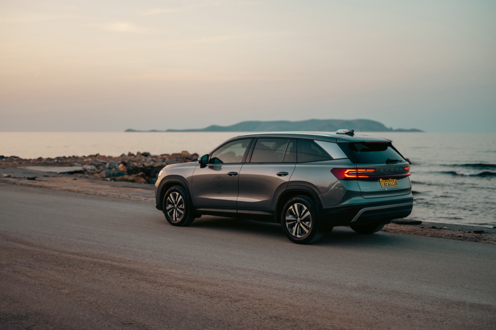 LP Taxi SUV rear view with tail lights on, parked by the sea